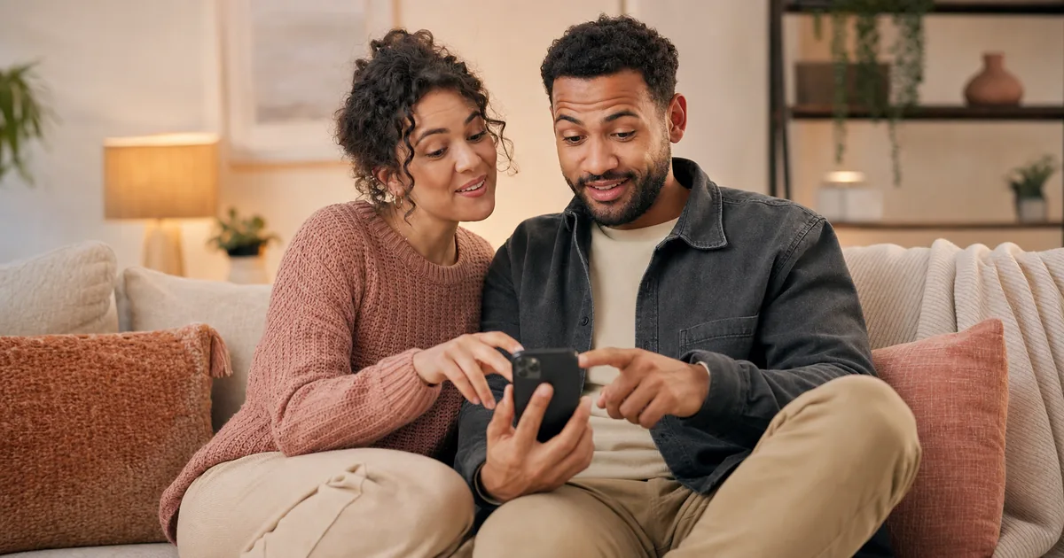 Couple complice qui joue à Tu préfères sur un téléphone